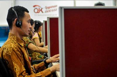 Petugas melayani pengaduan masyarakat melalui telepon di Call Center Otoritas Jasa Keuangan, Jakarta. Tempo/Tony Hartawan