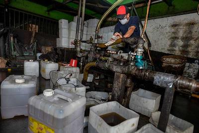 Pekerja mengisi minyak kedalam jirigen di Cipete, Jakarta, 29 November 2021. Tempo/Tony Hartawan