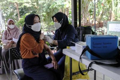 Tenaga kesehatan menyuntikan vaksin Covid-19 dosis ketiga kepada warga di RPTRA Bhinneka, Petukangan Utara, Jakarta, 25 Maret 2022. TEMPO/Muhammad Hidayat