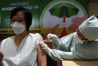 Tenaga kesehatan menyuntikan vaksin Covid-19 dosis ketiga kepada warga di pusat vaksinasi booster Universitas Parahyangan, Bandung, Jawa Barat, 25 Maret 2022. TEMPO/Prima Mulia