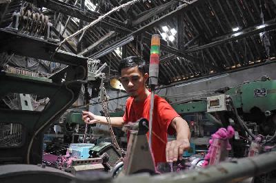 Pekerja pabrik mengoperasikan mesin tenun saat pembuatan kain untuk bahan kemeja dan celana di Kabupaten Bandung, Jawa Barat, 28 Maret 2022. TEMPO/Prima Mulia