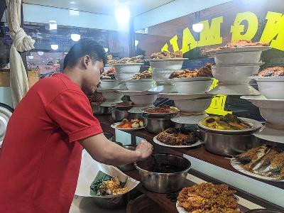 Pedagang melayani pembeli di rumah makan Padang di Bogor, 8 April 2022. Tempo/Bintari Rahmanita