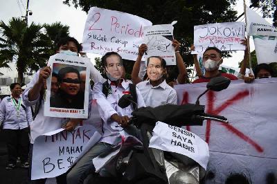 Mahasiswa memakai topeng Presiden Jokowi dan Menko Maritim dan Investasi Luhut Binsar Panjaitan saat unjuk rasa di depan Gedung DPRD Provinsi Jawa Barat di Bandung, 5 April 2022. TEMPO/Prima Mulia