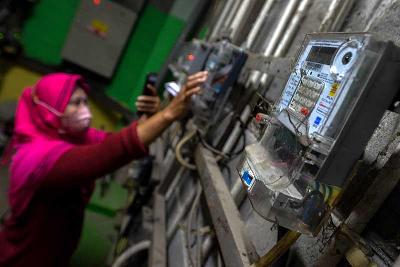 Pengguna listrik melakukan pengisian pulsa listrik di sebuah rusun di Jakarta, 1 Desember 2021. Tempo/Tony Hartawan