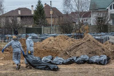 Teknisi forensik membawa jenazah warga sipil yang tewas dalam invasi Rusia-Ukraina saat pemakaman massal di kota Bucha, di luar Kyiv, Ukraina 13 April 2022. REUTERS/Volodymyr Petrov