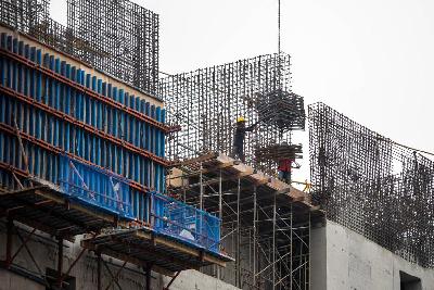 Pekerja menyelesaikan pembangunan gedung bertingkat di Jakarta, 4 Januari 2022. TEMPO/Tony Hartawan