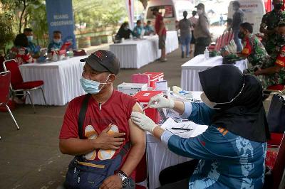 Petugas kesehatan TNI menyuntikkan dosis vaksin Covid-19 dosis ketiga di Pasar Induk Kramat Jati, Jakarta, 19 April 2022. Tempo/Hilman Fathurrahman W