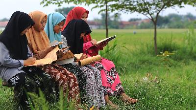 Students rote-learn Qur’anic verses in a paddy field adjacent to the Kempek Islamic Boarding School in Kempek village, Cirebon, West Java, April 21.
TEMPO/Subekti
