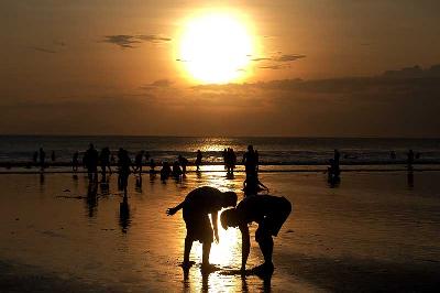 Wisatawan menikmati pemandangan matahari terbenam saat liburan Hari Raya Idul Fitri 1443 H di Pantai Kuta, Badung, Bali, 2 Mei 2022. ANTARA/Nyoman Hendra Wibowo