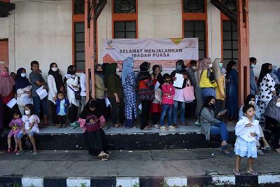 Warga antre mencairkan bantuan subsidi minyak goreng dan bantuan sembako di Kantor Pos Asia Afrika, Bandung, Jawa Barat, 15 April 2022.  TEMPO/Prima Mulia