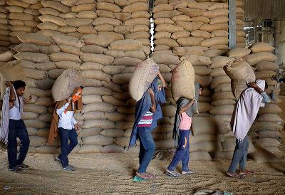 Pekerja membawa karung gandum untuk diayak di pabrik gandum di pinggiran Ahmedabad, India, 16 Mei 2022. REUTERS/Amit Dave