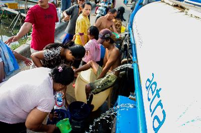 Warga mengisi wadah dengah air bersih di Marunda Kepu, Cilincing, Jakarta, 16 Mei 2022. TEMPO/ Magang/ Faisal Ramadhan