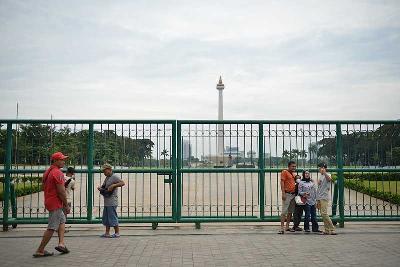 Warga berswafoto menjelang dibukanya kembali Monumen Nasional, Jakarta, 26 Mei 2022. Tempo/Febri Angga Palguna