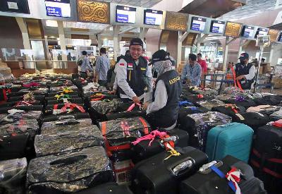 Sejumlah Petugas Panitia Penyelenggara Ibadah Haji (PPIH) Indonesia 1443 H/2022 merapihkan koper bawaannya di Terminal 3 Bandara Soekarno Hatta, Tangerang, Banten, 1 Juni 2022.  ANTARA/Muhammad Iqbal