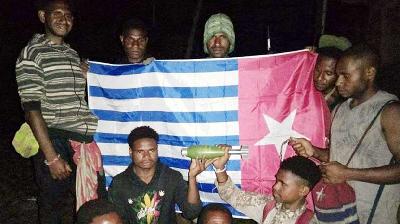 Warga dengan latar belakang bendera Bintang Kejora, menunjukan mortir yang dilengkapi baling-baling, di Distrik Kiwirok, Kabupaten Pegunungan Bintang, Papua. Istimewa