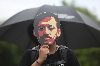 Aktivis melakukan aksi kamisan ke-714 dengan memegang topeng aktivis HAM Munir  di seberang Istana Merdeka, Jakarta, 20 Januari 2021.  TEMPO/ Hilman Fathurrahman W