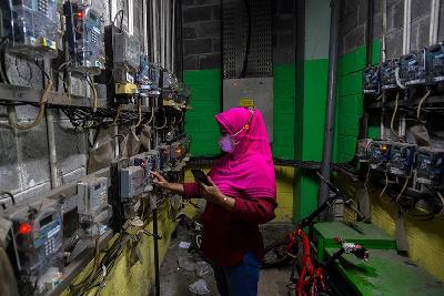 Penghuni rumah susun melakukan pengisian pulsa listrik di Jakarta. TEMPO/Tony Hartawan