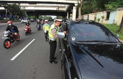Polisi melakukan penindakan sanksi tilang kepada pengendara mobil yang melanggar peraturan ganjil genap di Jalan Pramuka Raya, Jakarta, 13 Juni 2022. ANTARA/Reno Esnir