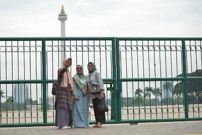 Warga berswafoto di Monumen Nasional, Jakarta, 26 Mei 2022. Tempo/Febri Angga Palguna