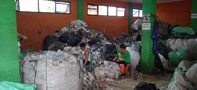 Dua petugas sedang menyortir sampah botol dan gelas plastik di Bank Sampah Induk Suku Dinas Lingkungan Hidup Jakarta Pusat, Cempaka Putih Timur, Jakarta, 16 Juni 2022. TEMPO/Indra Wijaya