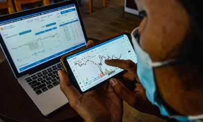 Investor mematau pergerakan kripto di layar komputer dan telepon seluler di Jakarta. TEMPO/Tony Hartawan