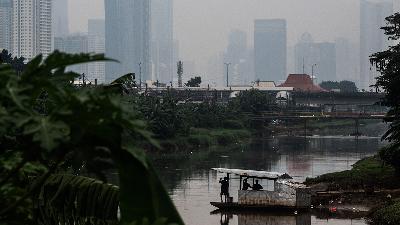 A wooden raft with pull-up rope crosses the West Flood Canal, against a background of skyscrapers partially obscured by smog in Jakarta, June 17.
ANTARA FOTO/Aprillio Akbar
