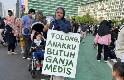 Orang tua pasien cerebral palsy, Santi Warastuti, melakukan aksi menuntut legalisasi ganja untuk medis saat hari bebas kendaraan di Jakarta, 26 Juni 2022. Twitter/ @andienaisyah