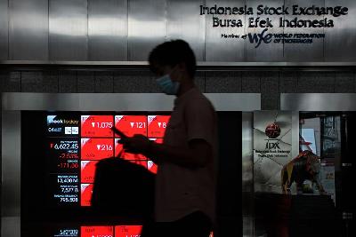 Karyawan melintas di depan layar pergerakan Indeks Harga Saham Gabungan (IHSG) di Bursa Efek Indonesia (BEI), Jakarta, 4 Juli 2022. Tempo/Tony Hartawan