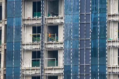 Pekerja tengah menyelesaikan pembangunan gedung hunian di kawasan Waduk Melati, Jakarta.  Tempo/Tony Hartawan