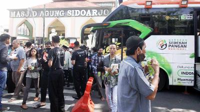 Warga menerima makanan dan minuman secara gratis dari Armada Humanity Food Bus Aksi Cepat Tanggap (ACT) di kawasan Masjid Agung Sidoarjo, Jawa Timur 10 Juni 2022. ANTARA/Umarul Faruq