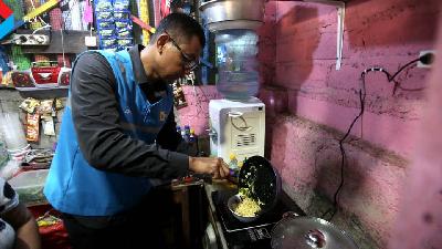 Direktur Utama PLN Darmawan Prasodjo melakukan demonstrasi memasak menggunakan kompor induksi di salah satu dapur pelaku usaha mikro kecil menengah (UMKM) di Pantai Mertesari, Sanur, Denpasar, Bali.
