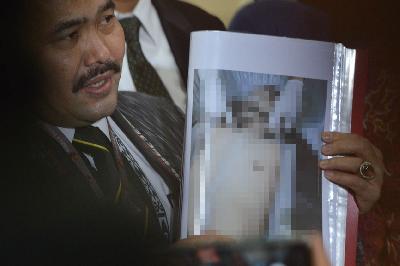 Kuasa hukum, Kamaruddin Simanjuntak, menunjukan foto jenazah Brigadir Nopryansah Yosua Hutabarat saat membuat laporan di Bareskrim Mabes Polri, Jakarta, 18 Juli 2022.  TEMPO/ Febri Angga Palguna