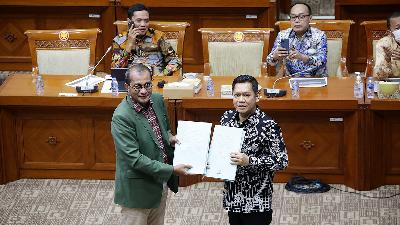 Deputy Minister of Justice and Human Rights Edward Omar Sharif Hiariej (left) submits the Criminal Code Draft and the revised Bill on Correctional to Adies Kadir (right), Deputy Chairman of Commission III of the House of Representatives, during a working meeting with the Commission at the Parliament Complex, Senayan, Jakarta, July 6.
TEMPO/M Taufan Rengganis
