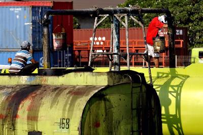 Pekerja mengisi truk tengki dengan Crude Palm Oil (CPO) di Pelabuhan Tanjung Priok, Jakarta. TEMPO/Tony Hartawan