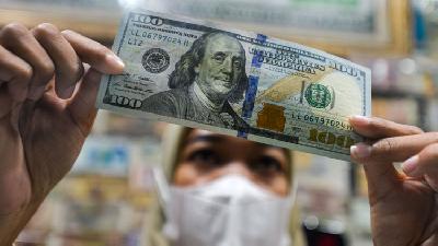 Pegawai penukaran valuta asing tengah menghitung uang pecahan 100 dolar Amerika Serikat di Jakarta, 29 Juni 2022. TEMPO/Tony Hartawan