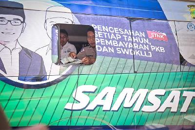 Petugas memeriksa surat kelengkapan bayar pajak dimobil Pajak Keliling Depok Bersama dan Terpadu (PALING DBEST) di Mutiara Depok, Sukmajaya, Depok, Jawa Barat, 29 Juli 2022. 
 ANTARA/Asprilla Dwi Adha
