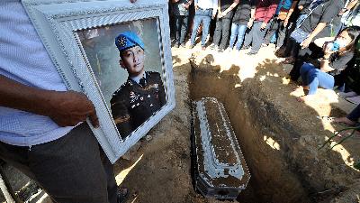 A relative holds a photo of the late Brig. Nofriansyah Yosua Hutabarat during the funeral after the second autopsy at Sungai Bahar, Muarojambi, Jambi, July 27.
ANTARA FOTO/Wahdi Septiawan
