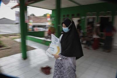 Warga membawa bantuan beras bantuan sosial PPKM di Sukatani, Tapos, Depok, Jawa Barat, 19 Agustus 2021. TEMPO/M Taufan Rengganis