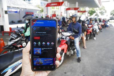 Pengendara sepeda motor menunjukan aplikasi MyPertamina saat antre BBM Pertalite di SPBU Pertamina Jalan RE Martadinata, Bandung, Jawa Barat, 29 Juni 2022. TEMPO/Prima Mulia