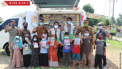 Beberapa petugas dari Gugah Nurani Indonesia dan Hyundai Motor berfoto bersama anak-anak warga Kecamatan Bojongmangu, Kabupaten Bekasi, Jawa Barat.