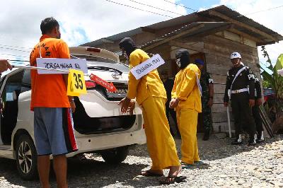 Tiga tersangka melakukan adegan memasukkan tubuh korban Arnold Lokbere ke dalam mobil saat mengikuti rekonstruksi pembunuhan dan mutilasi empat warga di Timika, Papua, 3 September 2022. ANTARA/Sevianto Pakiding