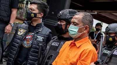Red and White Special Task Force officers escort a suspect before a hearing of an international network of methamphetamine case at the National Police Headquarters, Jakarta, April 2021.
ANTARA FOTO/M Risyal Hidayat
