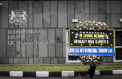 Petugas membawa karangan bunga bela sungkawa atas wafatnya Ratu Elizabeth II di Kedutaan Besar Inggris, Jakarta, 9 September 2022. ANTARA/Rivan Awal Lingga