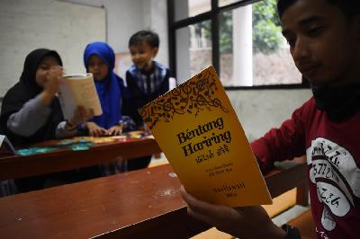 Penggiat komunitas Jatinangor Aksara Sunda, mengenalkan huruf-huruf Sunda pada anak-anak di masjid Al Jabbar,Jatinangor, Sumedang, Jawa Barat, 9 September 2022. TEMPO/Prima mulia