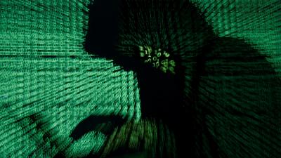 A man holds a laptop computer as cyber code is projected on him in this hacker illustration picture taken on May 13, 2017.  REUTERS/Kacper Pempel/Illustration 