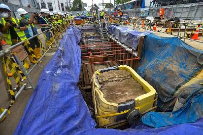 Sejumlah pekerja berusaha membersihkan terakota berupa saluran air yang berada di proyek pembangunan jalur MRT Jakarta fase 2 CP-203 di kawasan Glodok, Jakarta Barat, 20 September 2022. Tempo/Tony Hartawan