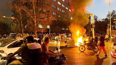 Motor polisi terbakar selama protes atas kematian Mahsa Amini, di Teheran, Iran 19 September 2022. WANA via REUTERS 