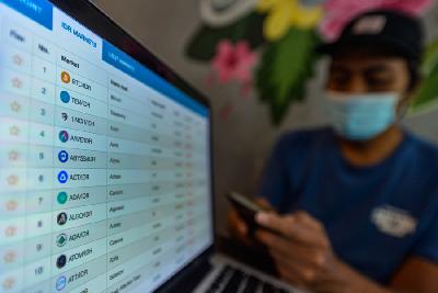 Pemain kripto mematau pergerakan Bitcoin di layar komputer dan telepon seluler miliknya di Jakarta. TEMPO/Tony Hartawan