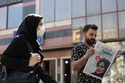 Seorang pria melihat koran dengan gambar sampul Mahsa Amini di Teheran, Iran, 18 September 2022. Reuters/Majid Asgaripour/WANA