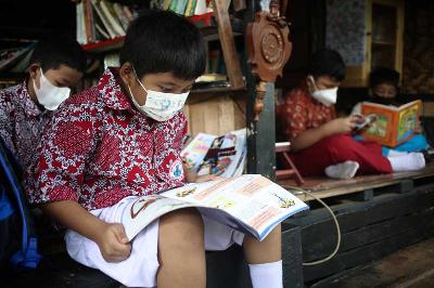 Anak-anak membaca buku di pustaka mini Bale Buku Meleduk 75 di Kelurahan Dukuh, Kramat Jati, Jakarta, 20 Januari 2022. Tempo/Hilman Fathurrahman W
